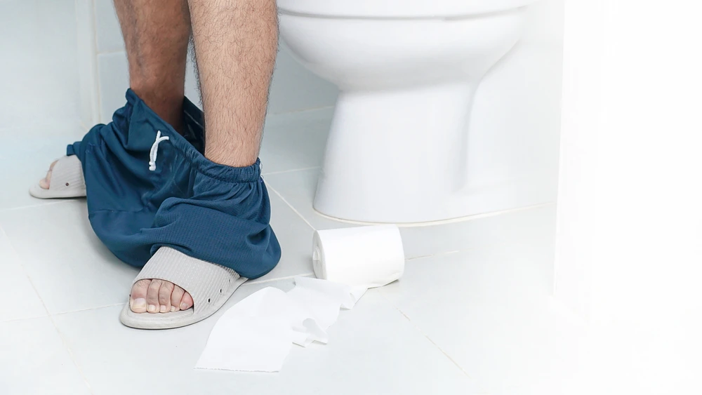 homme constipé aux toilettes qui se demande si son état peut être un signe d'un cancer de la prostate